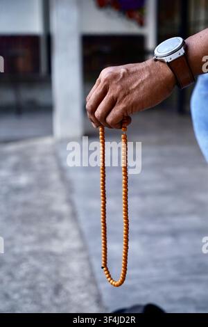 Hand, die Gebetsperlen für islamisches Dhikr hält Stockfoto