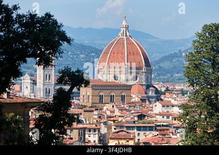Florenz, Italien - Mai 2026: Panoramablick auf die Kathedrale des Duomo di Firenze und die Kuppel des Brunelleschi, eingerahmt von Bäumen Stockfoto