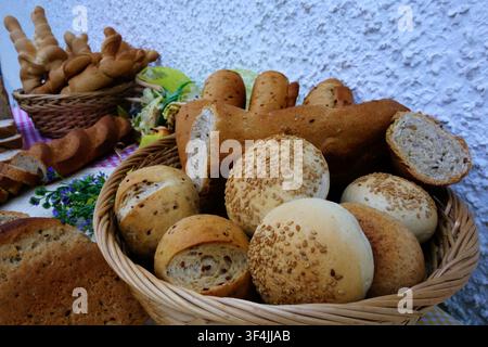 Reichhaltiges Sortiment an frisch gebackenem Brot und Gebäck, das im Freien auf einem Tisch ausgestellt ist. Eine herrliche Auswahl an verschiedenen Backwaren Stockfoto