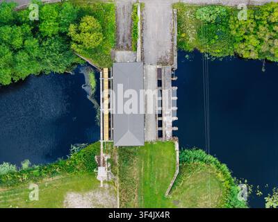 Luftbild der Brücke über den Vecberze-Fluss nahe seiner Mündung in den Lielupe-Fluss, umgeben von üppigen grünen Ufern und Bäumen in Kaigu ciems, Stockfoto