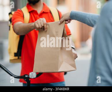 Kurier gibt Frau frisches Mittagessen, Essen zum Mitnehmen im Restaurant Stockfoto