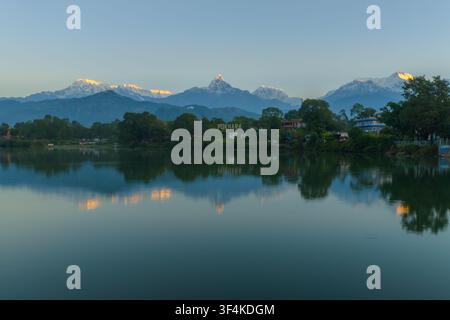 Luftaufnahme des Phewa-Sees mit der Annapurna-Bergkette, die sich im ruhigen Wasser bei Sonnenuntergang in Pokhara, Nepal, spiegelt. Stockfoto