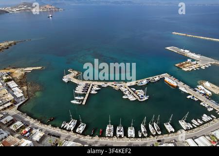 Luftaufnahme des Hafens von Chora auf der Insel Naxos, Griechenland, mit Yachten, Fährschiffen und Segelbooten, die um geschwungene Piers in klaren türkisfarbenen Ägäischen Gewässern vertäut sind. Stockfoto