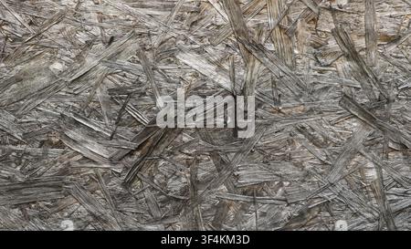strukturierte Oberfläche einer OSB-Platte aus gepressten Holzspänen. Die Textur ist gealtert, rau und chaotisch. Altes graues gepresstes Holzspanplattenmaterial Stockfoto