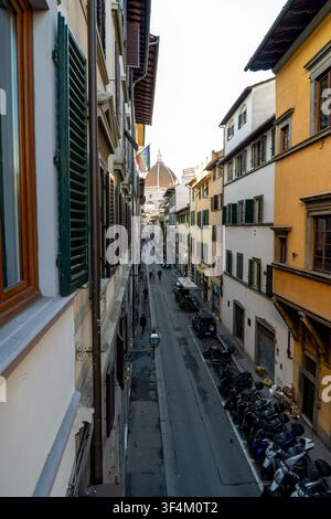 Eine schmale Straße in Florenz, Italien, gesäumt von historischen Gebäuden und führend auf die ikonische Kuppel der Kathedrale von Florenz zu. Florenz, Italien, 2026 Stockfoto