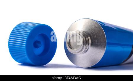 offenes blaues Metallröhrchen isoliert auf weißem Hintergrund, ungeöffnete Aluminiumdüse und gerippte Plastikkappe, Seitenansicht in Makro-Nahaufnahme Stockfoto