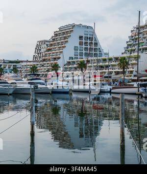 Luxus-Yachten und Boote, die im Yachthafen von La Grande-Motte, Frankreich, vor Anker liegen, mit seiner ikonischen modernistischen Pyramidenarchitektur, die sich im ruhigen Wasser spiegelt Stockfoto