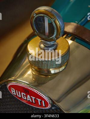 Nahaufnahme des Messing-Radiator-Temperaturmessgeräts Boyce MotoMeter und des roten Emaille-Emblems an einem klassischen Vintage-Bugatti-Automobil Stockfoto