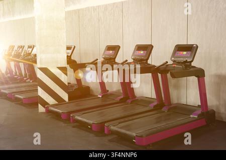 Cardio-Zone mit Laufbändern in einem sonnendurchfluteten Fitnessstudio, selektive Schärfe Stockfoto
