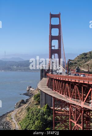 Die Golden Gate Bridge überspannt den Eingang zur San Francisco Bay in Kalifornien mit ihrer atemberaubenden orangefarbenen Stahlarchitektur und dem regen Fahrzeugverkehr. Stockfoto