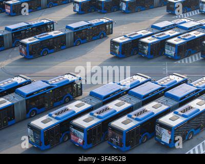 Krakau, Polen – 18. Juli 2026: Luftbild eines großen Busdepots mit zahlreichen blauen Gelenkbussen, die in ordentlichen Reihen auf einem Asphaltplatz geparkt sind. Stockfoto