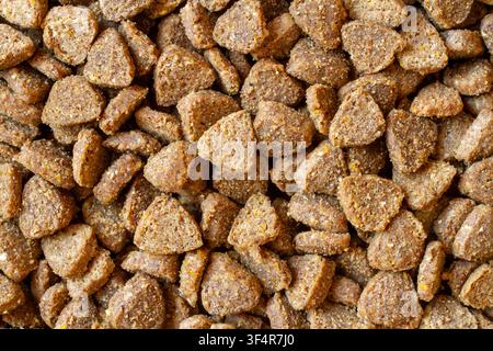 Nahaufnahme von gelbem trockenem granuliertem Katzenfutter. Textur von trockenem Tierfutter. Stockfoto