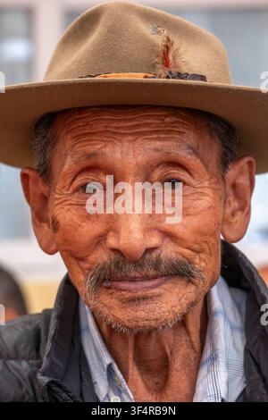 Porträt eines älteren Mannes mit einem Hut, der mit einer Feder geschmückt ist, in Dharamsala, Himachal Pradesh, Indien. Stockfoto