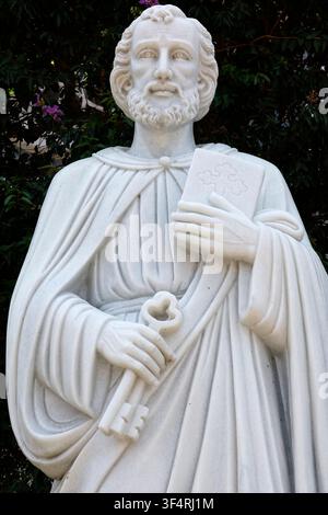 Marmorstatue des heiligen Petrus, Apostel und erster Papst, der die Schlüssel zum Himmelreich und ein mit einem Kreuz verziertes Buch hält. Thong Nhat, Vietnam. Stockfoto