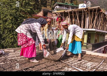 Frauen arbeiten auf einer Baustelle in Dharamkot, Himachal Pradesh, Indien, und handhaben Zement für eine neue Struktur Stockfoto