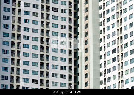 Eine Nahaufnahme der Fassade eines modernen Wohngebäudes, das ein Muster aus Fenstern und Balkonen aufweist, das typisch für zeitgenössische urbane Architektur ist Stockfoto