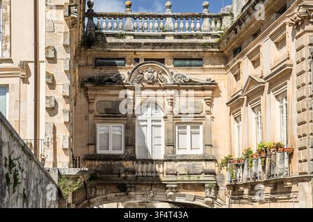 Verzierter Steinbrückenzug, der historische Kalksteinbauten in Ragusa Ibla, Sizilien, Italien, verbindet Stockfoto