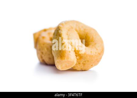 Eine Nahaufnahme eines Haufens goldener Taralli, traditioneller italienischer ringförmiger Cracker, fotografiert auf weißem Hintergrund. Knuspriger, herzhafter Snack perfekt für Ap Stockfoto