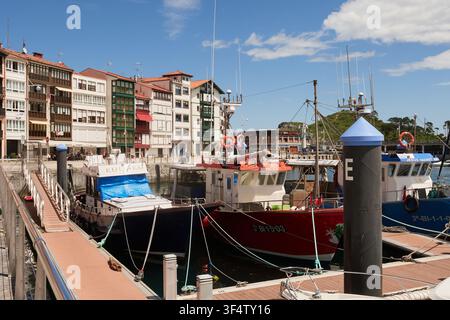 Fischerboote, die im Hafen von Lekeitio mit traditionellen Uferhäusern liegen, Bizkaia, Spanien Stockfoto