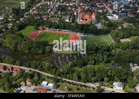Luftbild eines Sportkomplexes mit einer Laufbahn und einem Fußballfeld, das neben einem Fluss liegt, umgeben von üppigen Bäumen und städtischen Gebäuden in Sa Stockfoto