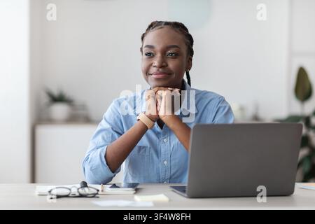 Schöne Junge Schwarze Geschäftsfrau Daydreaming Am Arbeitsplatz Im Büro Stockfoto