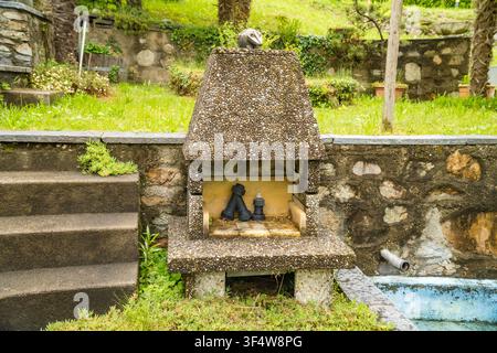 Steinerner Gartenkamin im Nahaufnahme mit einem Vogel, der oben sitzt, Caslano Stockfoto