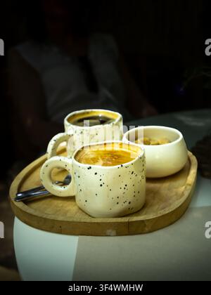 Frisch gebrühter Kaffee, serviert auf einem Holztablett in einem gemütlichen Café Stockfoto