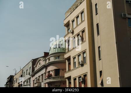 Wohngebäude mit klassischer und moderner Architektur säumen eine Straße in Belgrad, Serbien. Urbane Stadtsilhouette mit Balkonen und markanten Stockfoto