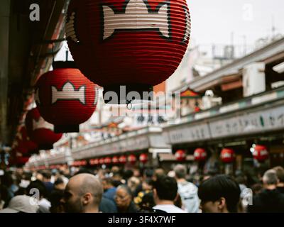 Rote Papierlaternen, die über Menschenmassen an der Nakamise-dori-Einkaufsstraße in der Nähe des Senso-ji-Tempels in Asakusa, Tokio, hängen Stockfoto