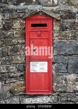Ein historischer roter viktorianischer Briefkasten mit dem königlichen VR-Monogramm ist in eine traditionelle Trockenmauer in Bradwell, Peak District, eingelassen Stockfoto