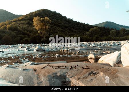 Ansicht von oben des weiblichen Namens „Azura“, der während des warmen goldenen Lichts der Goldenen Stunde in nassen Strandsand geschrieben wurde. Stockfoto