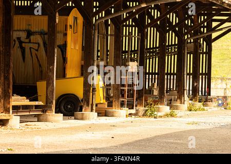 Innenansicht einer traditionellen Holzbarn mit landwirtschaftlichen Geräten und warmem natürlichem Licht. Perfekt für Landwirtschafts- und ländliche Lebensstilkonzepte. Stockfoto