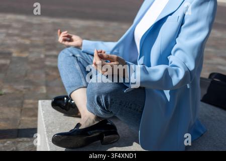 Geschäftsfrau praktiziert Meditation in einer friedlichen Umgebung im Freien und findet geistige Balance Stockfoto