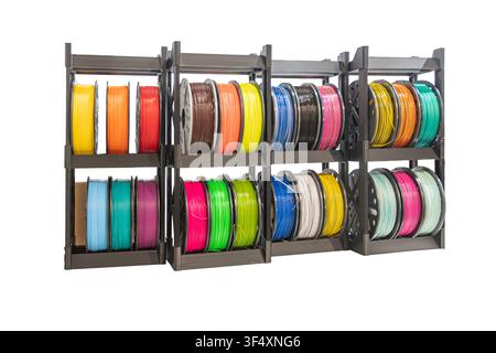 Ausstellungsstück für 3D-Druckmaterialien mit farbenfrohen Filamenten, die ordentlich auf einem Metallgestell angeordnet sind, lebendige Farben und organisierte Anordnung in einem sauberen Arbeitsbereich Stockfoto