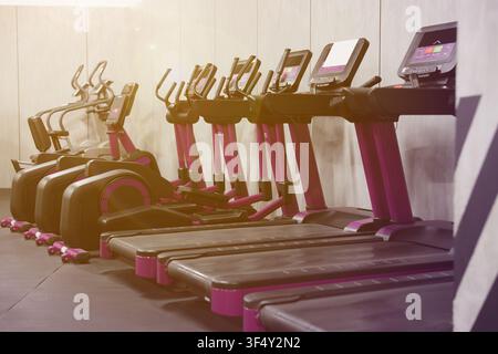 Cardio-Zone mit Laufbändern in einem sonnendurchfluteten Fitnessstudio, selektive Schärfe Stockfoto