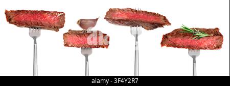Gegrillte Fleischsteaks auf Gabeln vor weißem Hintergrund, arrangiert Stockfoto