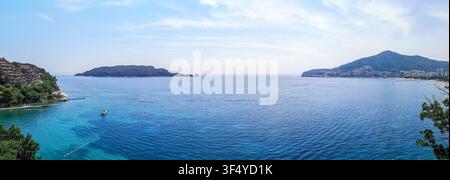 Weite Panoramasicht der Bucht von Budva und der Insel Sveti Nikola in Montenegro. Ruhiges türkisfarbenes Meer und grüne Hügel bilden eine malerische Küstenlandschaft Stockfoto