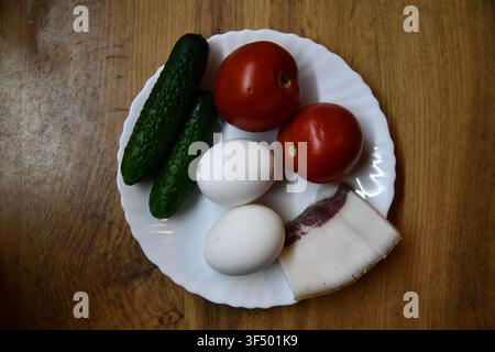 Herzhaftes englisches Frühstück mit Eiern, Speck, Würstchen, Bohnen, Tomate und Toast, serviert auf einem Holztisch Stockfoto