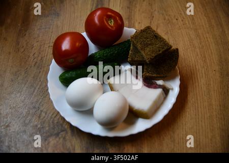 Herzhaftes englisches Frühstück mit Eiern, Speck, Würstchen, Bohnen, Tomate und Toast, serviert auf einem Holztisch Stockfoto