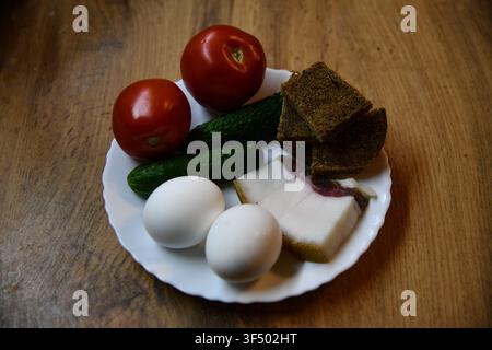 Herzhaftes englisches Frühstück mit Eiern, Speck, Würstchen, Bohnen, Tomate und Toast, serviert auf einem Holztisch Stockfoto