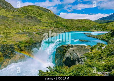 Mächtiger Salto-Grande-Wasserfall stürzt in ein türkises Becken mit einem Regenbogen im Torres-del-Paine-Nationalpark, Chile, Patagonien. Stockfoto