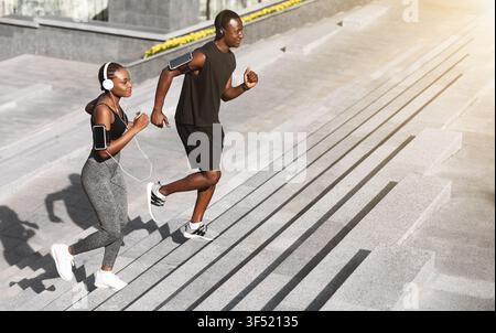 Cardio-Training. Lächelndes Afrikanisches Paar Beim Joggen Auf Stufen Im Urban Park Stockfoto