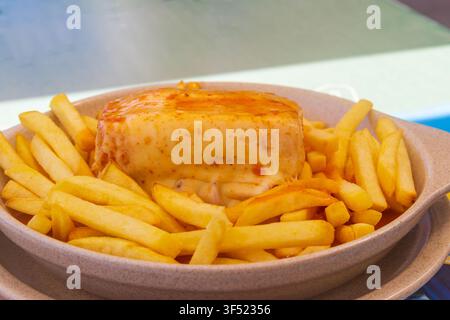 Francesinha-Sandwich mit Pommes frites auf einem Teller. Typisches Essen aus Porto, Portugal Stockfoto