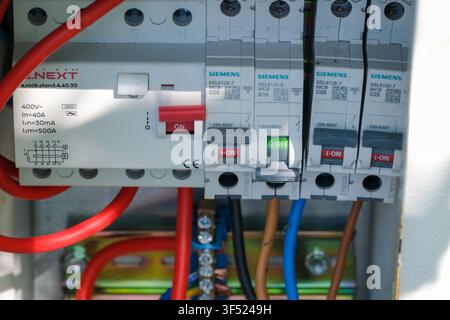 KIEW, UKRAINE - 30. JULI 2026: Nahaufnahme eines Stromverteilungsschranks mit Siemens-Leistungsschaltern, Stromstoßschalter und elektrischen Kabeln Stockfoto