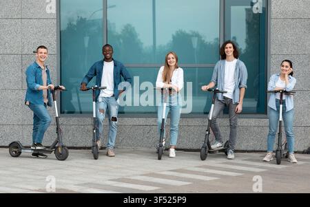 Gruppe von jungen Erwachsenen fährt Elektroscooter in einer städtischen Umgebung, glücklich und entspannt Stockfoto