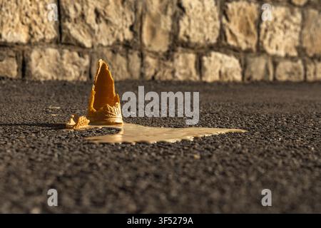 Eine heruntergefallene Eiscremepfanne, die auf einem Bürgersteig liegt, nachdem ein Kind versehentlich sein Eis verloren hat. Konzept von Kindheitsmomenten, Sommeraktivitäten, Enttäuschung Stockfoto