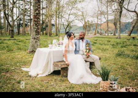 Frischvermähltes Paar genießt ein romantisches Picknick im Freien bei einer heimlichen Hochzeit Stockfoto