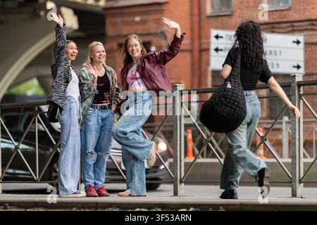 Junge Frauenfreundinnen begrüßen sich auf der Stadtstraße Stockfoto