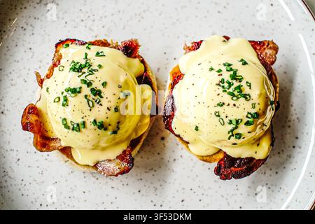 Leckere Eggs Benedict mit knusprigem Speck zum Brunch Stockfoto