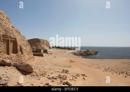 Die beiden Tempel von Abu Simbel, die sich in die von Menschenhand geschaffenen Klippen entlang des Nasser-Stausees in Ägypten einfügen, überragen eine Handvoll Touristen Ende Mai. Stockfoto